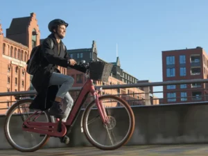 A lady riding an ebike in an urban environment